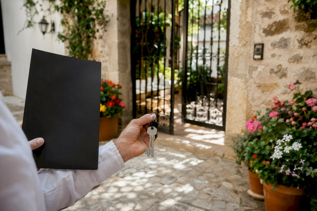 Hands holding keys and contract at apartment entrance