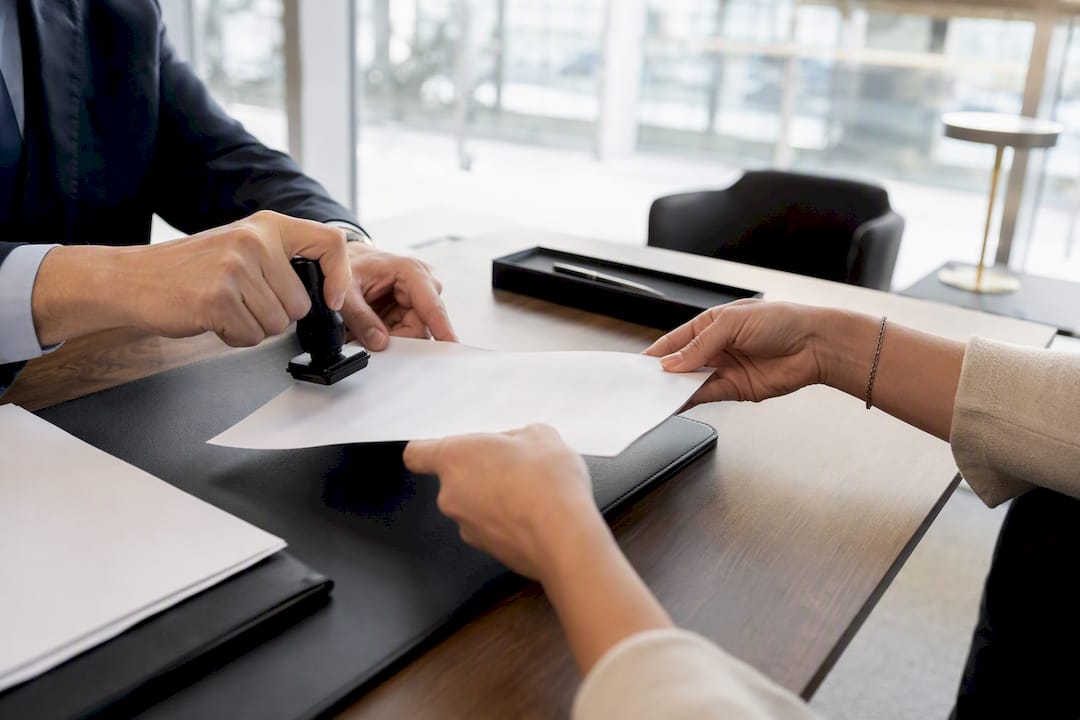 Hands signing mortgage cancellation deed