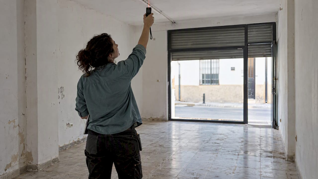 Architect checks ceiling height in vacant premises